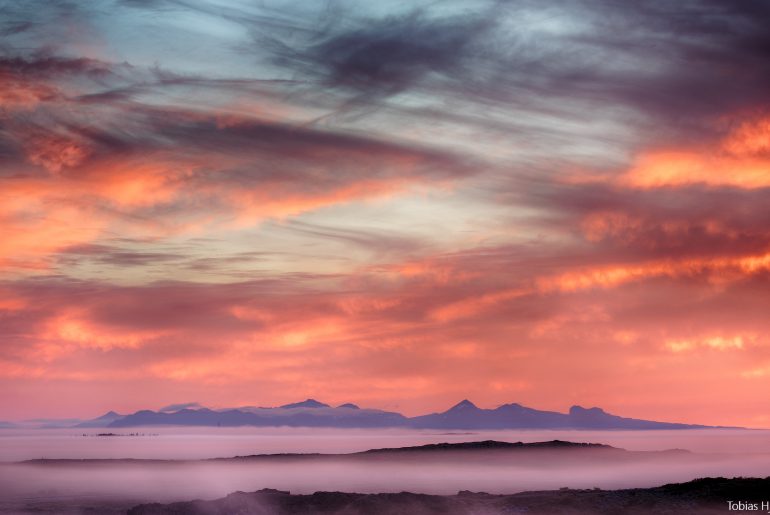 Sunset over Faxabugten with distant mountains